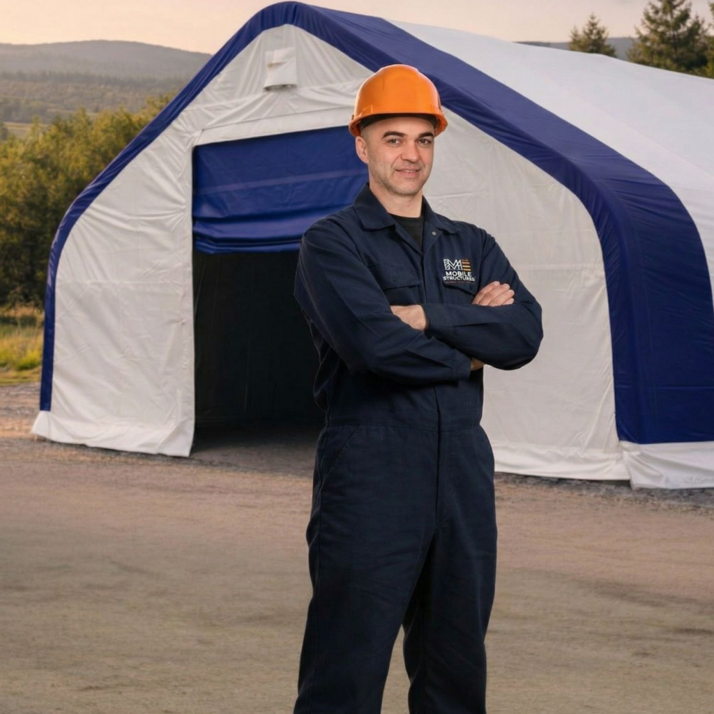 Persoană cu cască de protecție în fața unei hale demontabile cu structură metalică și acoperire PVC